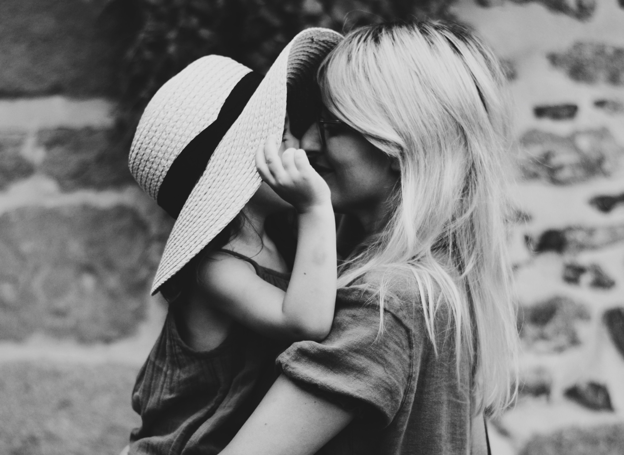 Mother holding a child wearing her hat
