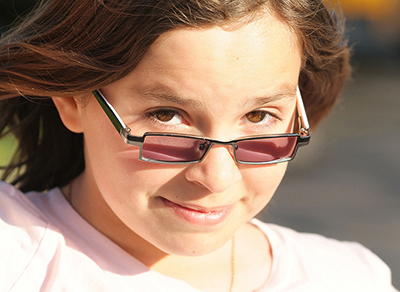 Sly girl peering over her glasses