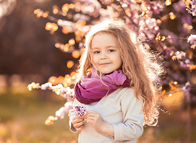 Girl wearing a beautifl purple scarf near a cherry tree