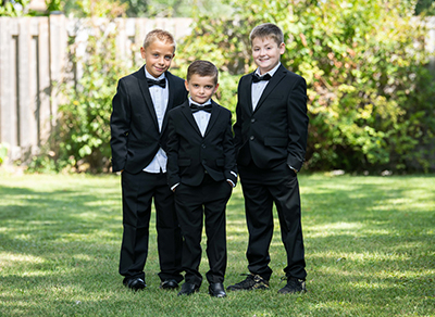 Three boys in black suits wearing bow ties