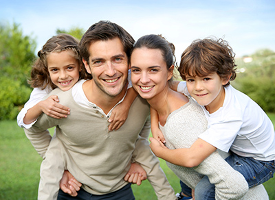 Family photographed in front of a park