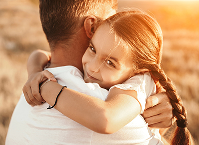 Golden hour picture of a father embracing his daughter
