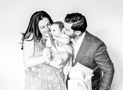Mother and father kissing a baby