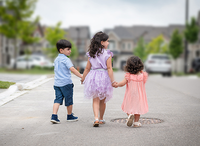 Three kids walking holding hands