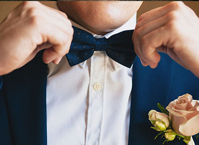Groom adjusting his tie before the wedding