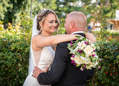 Bride and groom embracing in a park at a golden hour